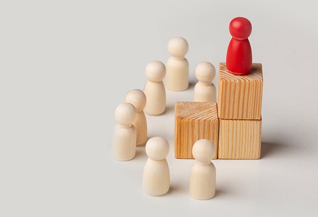 A collection of wooden blocks accompanied by a person figure featuring the Extended Diploma in Global Business Management.