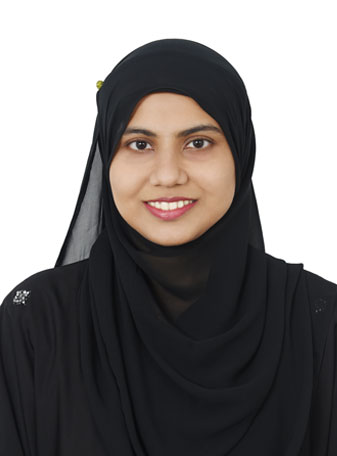 A woman in a black hijab smiling.